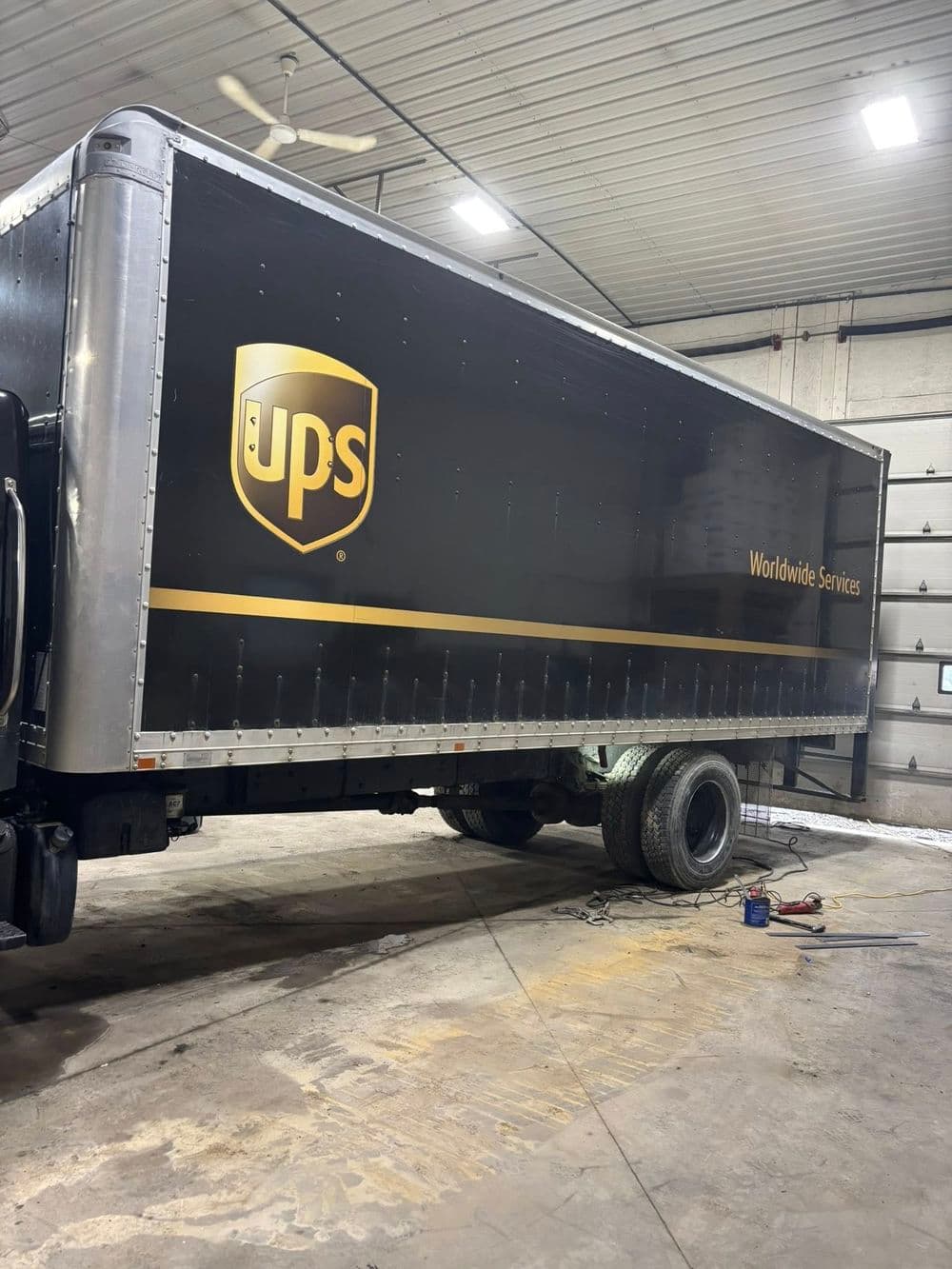 UPS truck in a warehouse with "Worldwide Services" branding, showcasing delivery logistics.